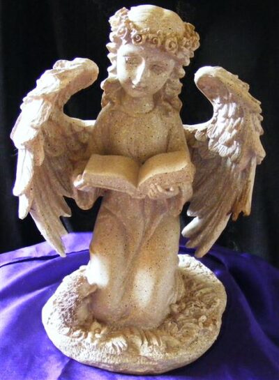 ivory kneeling angel reading a book