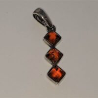three square amber stones set in long silver pendant
