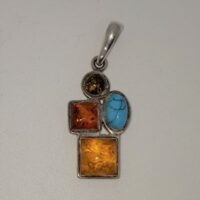 silver pendant set with 3 different coloured ambers and turquoise