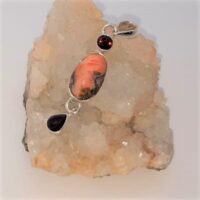 Oval fire opal with round and teardrop shaped garnets in silver pendant