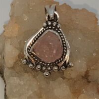 rough kunzite in fancy design silver setting pendant close up