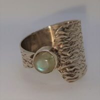 wide to narrow textured silver ring set with a round labradorite stone