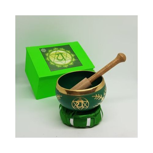 green singing bowl with gold decoration with wooden beater green cushion and box beater in bowl on cushion