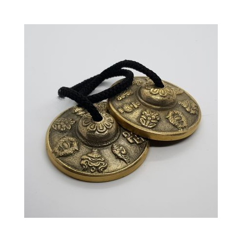 gold coloured tingsha with decorative tops and symbols inside 4 top view