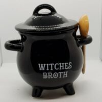 black cauldron shaped soup bowl with lid and ceramic spoon words in white witches broth