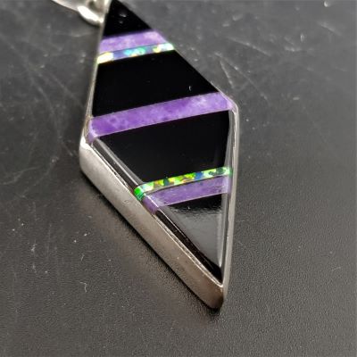 native american made silver diamond shaped pendant set with black onyx charoite and opal close up