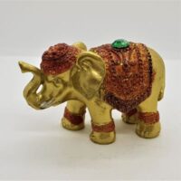 gold elephant incense holder with red coloured decoration and green jewel
