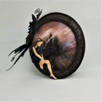 resin fairy seated on picture frame with picture of castle behind showing removable metals wings