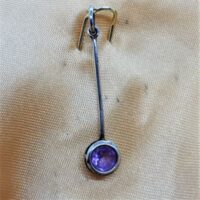 small faceted amethyst in silver setting close up