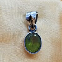 oval facetted peridot in silver pendant close up