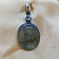 oval green rutile in water clear quartz in silver pendant with peridot