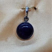 small round sugilite set in silver pendant close up