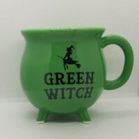 cauldron shaped mug green with black print witch on broomstick and word green witch