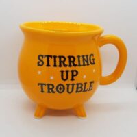 cauldron shaped mug orange with black print stirring up trouble